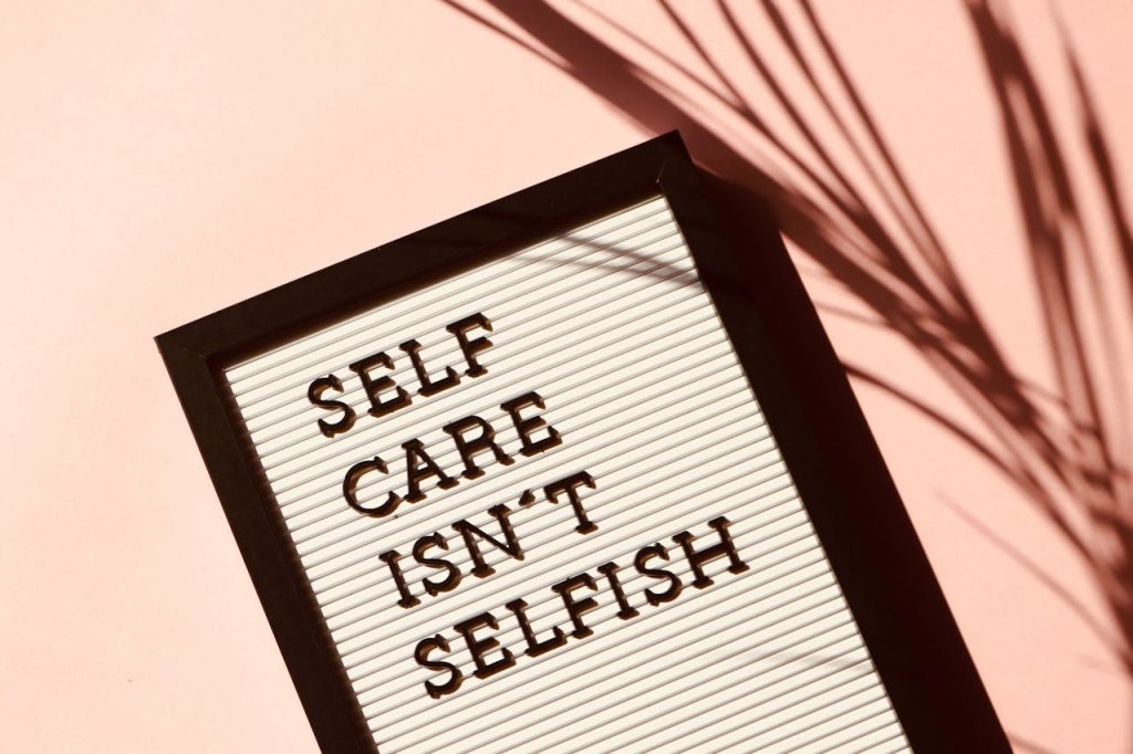 self-care-isn-t-selfish-signage-2821823 Letter board displaying Self Care Isnt Selfish with artistic shadow on pink background.